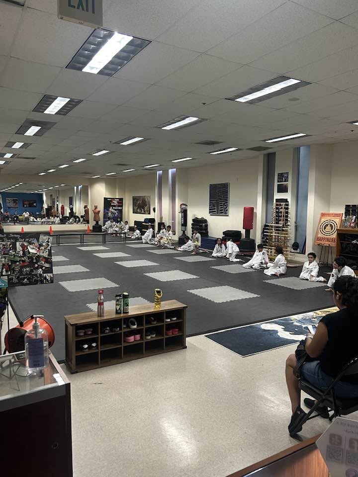 Youth Taekwondo class seated on the training floor