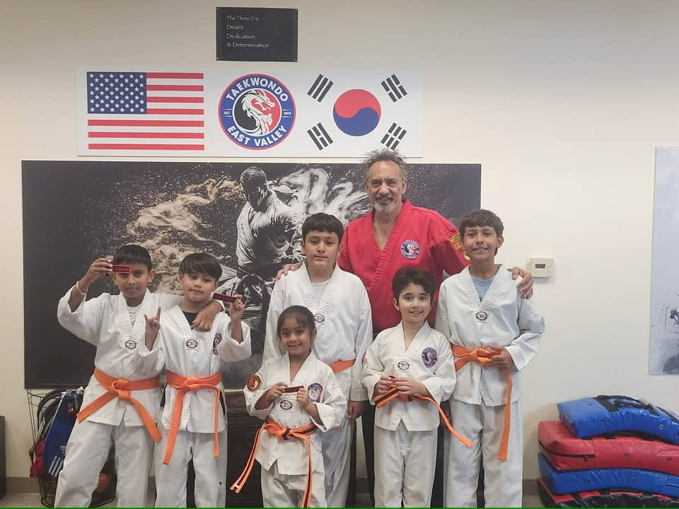 Young East Valley TEK students celebrating a belt promotion with Kwan Jang Nim Scott Cordero